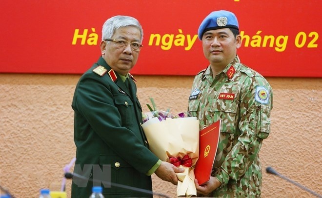 Deputy Minister of National Defence Sen. Lieut. Gen. Nguyen Chi Vinh presents the President’s decision to Lieut. Colonel Nguyen Kim Tinh. (Photo: VNA)