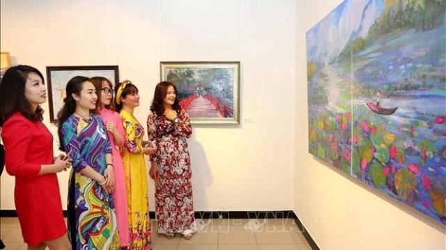 Visitors admiring a photo on display at the exhibition (Photo: VNA)