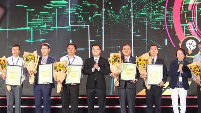 Minister of Science and Technology Chu Ngoc Anh (centre) presents the awards to businesses at the ceremony in Ho Chi Minh City on February 20 (Photo: VNA)