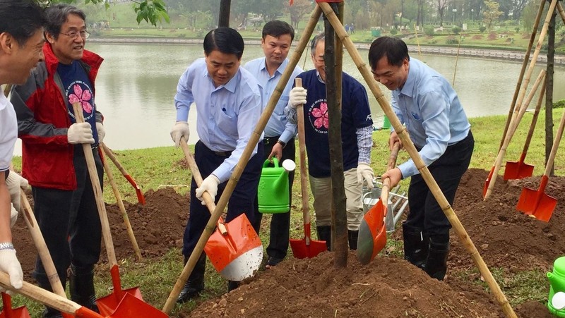 Chairman of Hanoi People’s Committee Nguyen Duc Chung and other delegates plant trees at the Hoa Binh Park