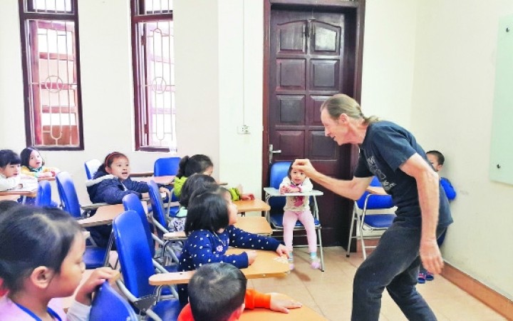Paul George Harding is teaching English to children. 