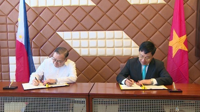 Vietnamese Deputy PM and FM Pham Binh Minh (R) and Philippine Foreign Secretary Teodoro Lopez Locsin (L) sign the minutes of the ninth meeting of the Vietnam - Philippines Joint Commission for Bilateral Cooperation in Manila on March 6. (Photo: MOFA)