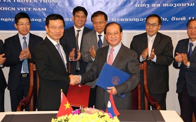 Minister of Information and Communications Nguyen Manh Hung (left) and Lao Minister of Information, Culture and Tourism Bosengkham Vongdala ink cooperation deals during their talks on March 11. (Photo: NDO)