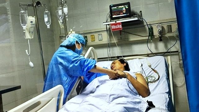 An adult patient following a liver transplant undergoing postoperative care. (Photo: NDO/Trung Hieu)