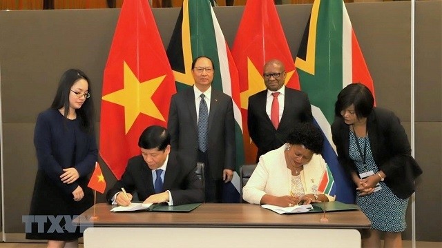 Vietnamese Deputy Foreign Minister Nguyen Quoc Cuong and South African Deputy Minister of International Relations and Cooperation Reginah Mhaule sign the meeting's minutes. (Photo: VNA)