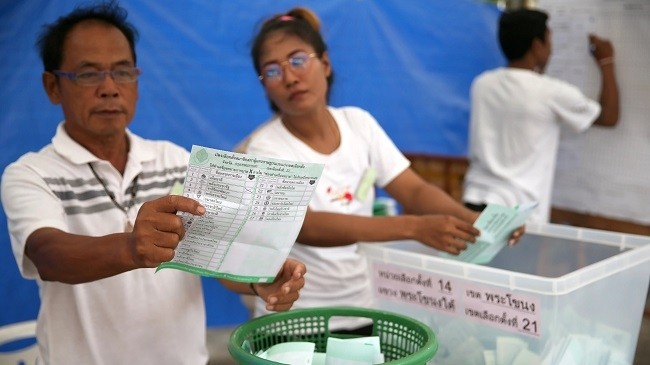 An electoral member shows a ballot during the vote counting in Bangkok on March 24. (Photo: Reuters)