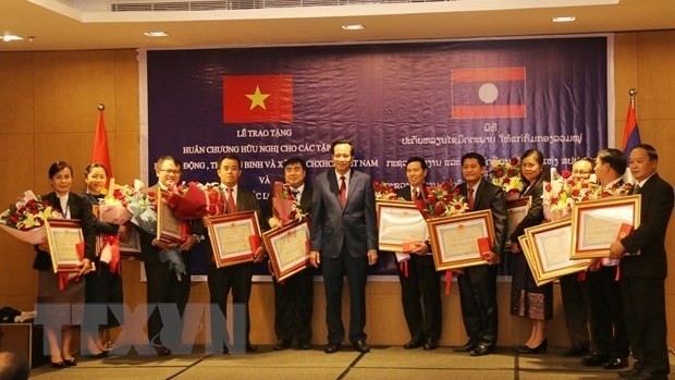 The Lao minister grants the Friendship Order to 16 MoLISA units. (Photo: VNA)