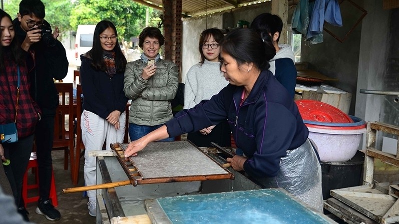 Artisan Hoang Thi Hau shows visitors how to acquire paper fibres. 
