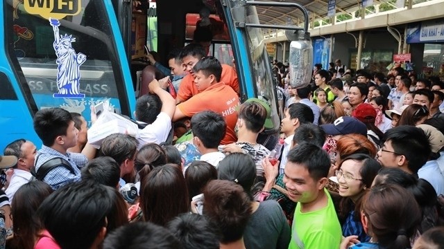 Passengers jostle to get on a bus at My Dinh Bus Station.