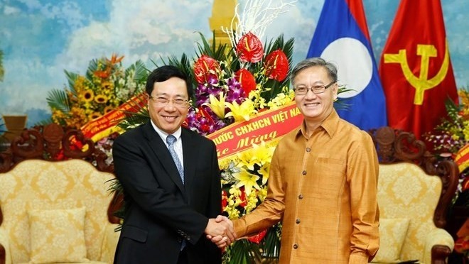 Deputy Prime Minister and Foreign Minister Pham Binh Minh (L) and  Lao Ambassador to Vietnam Thongsavanh Phomvihane (Photo: VNA)