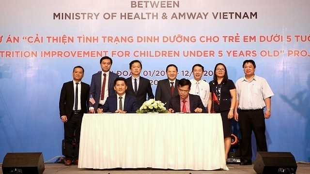 Representatives from the Ministry of Health and Amway Vietnam sign the agreement in Hanoi on April 23. (Photo: NDO/Tran Nguyen)