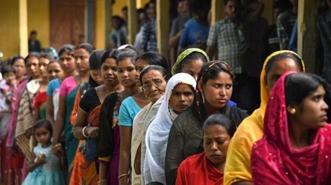 Indian women holding umbrellas wait in queue to cast their votes at a polling station in Jorhat district of Assam, India, 11 April 2019. (Photo: EPA/STR)