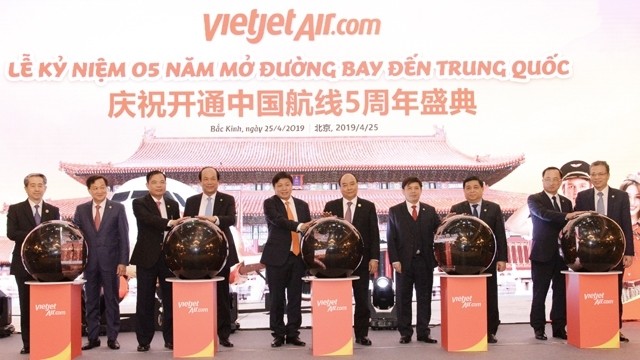 PM Nguyen Xuan Phuc (fifth from right) and a high-ranking delegation of Vietnam attended a ceremony marking the fifth anniversary of the first flight of budget carrier Vietjet Air to China in Beijing, China on April 25. (Photo: NDO/Ha Thanh Giang)