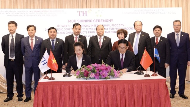 PM Nguyen Xuan Phuc (C, standing) witnesses the signing of a MoU on strategic cooperation in distributing dairy products between Vietnam’s TH Group and Wuxi Jinqiao International Food City. (Photo: NDO/Ha Thanh Giang)