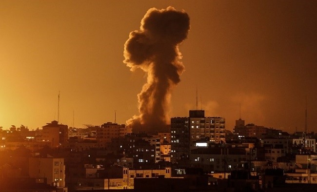 Illustrative: A picture taken on November 12, 2018, shows smoke rising above the building housing the Hamas-run television station al-Aqsa TV in the Gaza Strip during an Israeli air strike. (Photo: AFP)