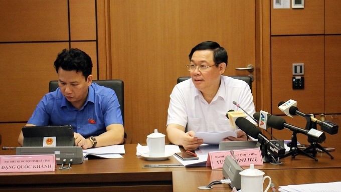 Deputy PM Vuong Dinh Hue (R) speaks during the group discussion session on May 22. (Photo: VGP)