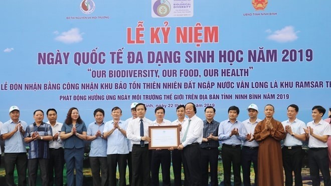 Deputy Minister of Natural Resources and Environment Vo Tuan Nhan (R) presents a certificate recognising Ninh Binh's Van Long Wetland Nature Reserve as Vietnam's 9th Ramsar site  as part of the ceremony (Photo: VNA)