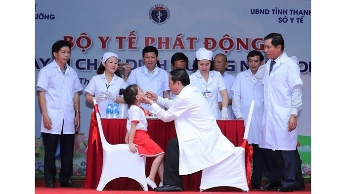 Deputy Health Minister Nguyen Viet Tien offers Vitamin A supplement to a local girl during the launch of the National Micronutrient Day 2019 in the central province of Thanh Hoa on May 28, 2019. (Photo: NDO/Mai Luan)