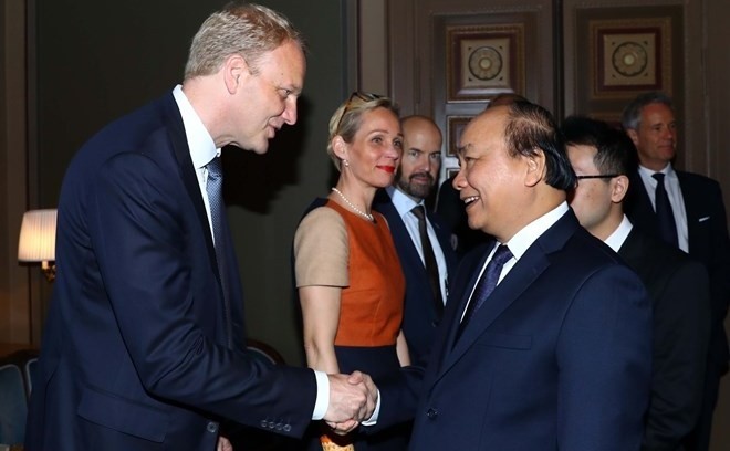 Prime Minister Nguyen Xuan Phuc (R) shakes hands with a Swedish business executive at a meeting in Stockholm on May 27 (Photo: VNA)