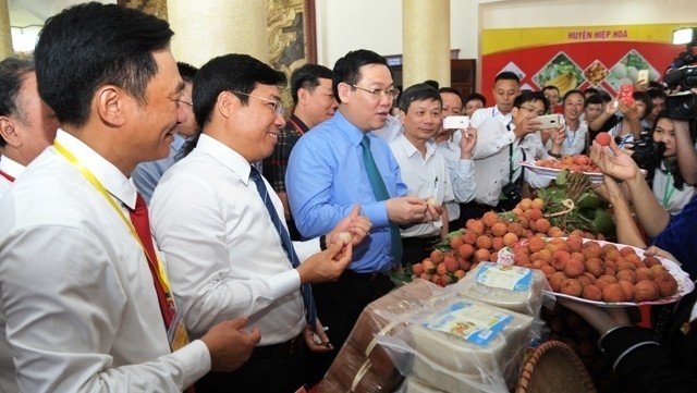 Deputy PM Vuong Dinh Hue and other delegates visit pavilions showcasing local agricultural products at the forum. (Photo: moitruong24h.vn)