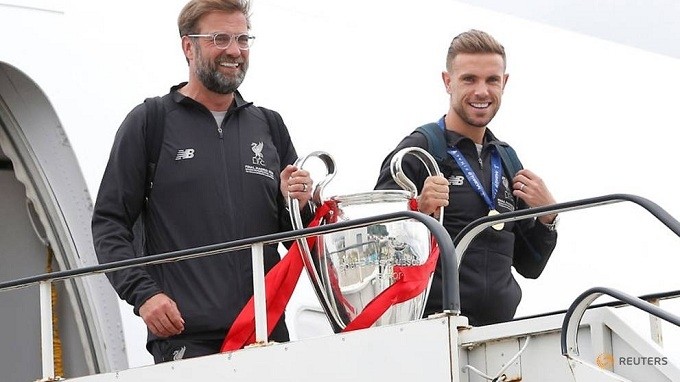 Liverpool manager Juergen Klopp and captain Henderson hold the Champions League trophy when they arrive back to Liverpool. (Reuters)