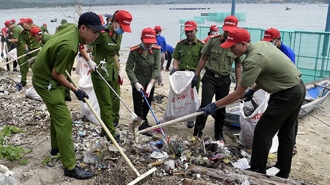 Police forces and local youngsters join hands to collect garbage in the coastal area of Phuoc Ly street, Xuan Yen ward, Song Cau town, Phu Yen province during the “Let’s clean the sea" 2018 campaign. (Photo: NDO/Trinh Ke)