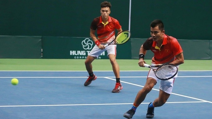 Vietnam’s Pham Minh Tuan (L) and Le Quoc Khanh in action during a men’s doubles match.