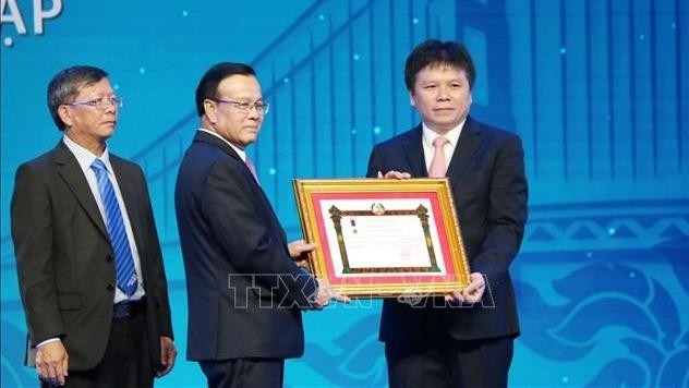 Lao Deputy Prime Minister Somdee Duangdee (middle) awarded the Labour Order, first class, to the LaoVietBank. (Photo: VNA)