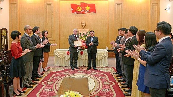 Prof. Dr. Nguyen Xuan Thang (R) presents the insignia of the Ho Chi Minh National Academy of Politics to Australian Ambassador to Vietnam Craig Chittick. (Photo: hcma.vn)