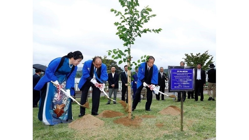 Prime Minister Nguyen Xuan Phuc (second from left), his spouse and Toshihiro Nikai, plant a tree to mark the special event. (Photo: VNA)