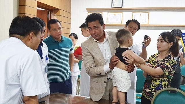 Professor Arun Ranganathan (C) and doctors from the Orthopaedic Trauma Department under the Hanoi-based Bach Mai Hospital examine a child patient with scoliosis.