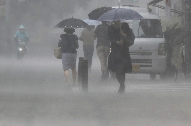 Pedestrians holding an umbrella struggle against a heavy rain in Miyazaki on July 2, 2019. (Photo: IC)