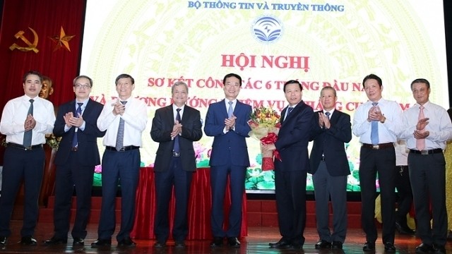 Minister of Information and Communications Nguyen Manh Hung presents flowers to representatives from Bac Ninh and Bac Kan provinces. (Photo: NDO)