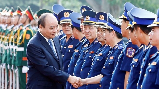 Prime Minister Nguyen Xuan Phuc shakes hands with officials of the Vietnam Coast Guard High Command in Hanoi on July 11 (Photo: VNA)