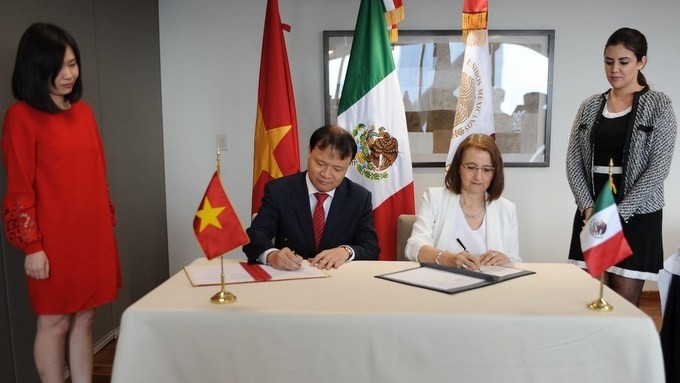 Vietnamese Deputy Minister of Industry and Trade Do Thang Hai and Mexican Deputy Minister of Foreign Trade Luz María de la Mora sign the agreement document of the working session. (Photo: VNA)