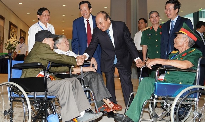 PM Nguyen Xuan Phuc talking with outstanding heavily wounded war veterans (Photo: VGP)