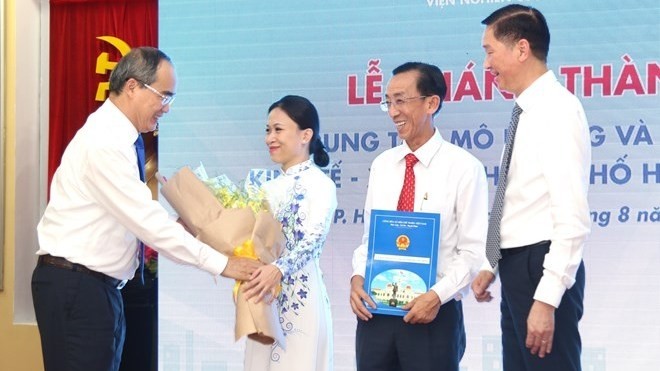 Secretary of the HCM City Party Committee Nguyen Thien Nhan (L) congratulates leaders of the socio-economic simulation and forecast centre at the inaugural ceremony on August 1 (Photo: VNA)