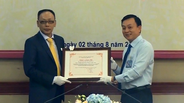 Director of Ho Chi Minh Museum, Dr Vu Manh Ha (R) presents a letter of gratitude to Vuong Quynh Xuan for his family’s donation of two valuable pieces of Uncle Ho’s memorabilia to the museum. (Photo: VTV)
