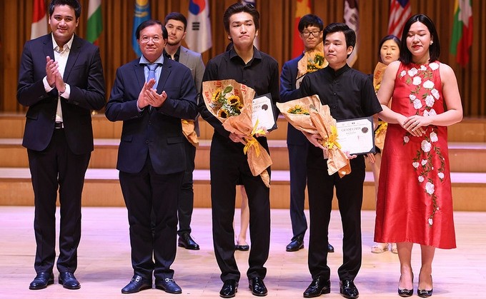Ruslan Turuntayev from Kazakhstan and Park Gang Hyeon from the RoK receive the Grand Prix in the violin category. (Photo: hanoimoi.com.vn)