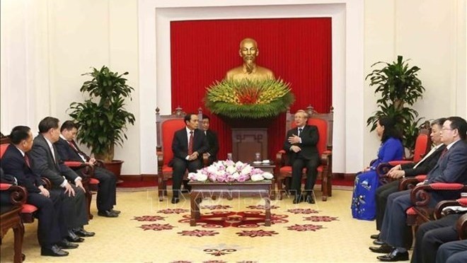 Politburo member Tran Quoc Vuong (R) hosts a reception for a Lao delegation in Hanoi on August 15. (Photo: VNA)