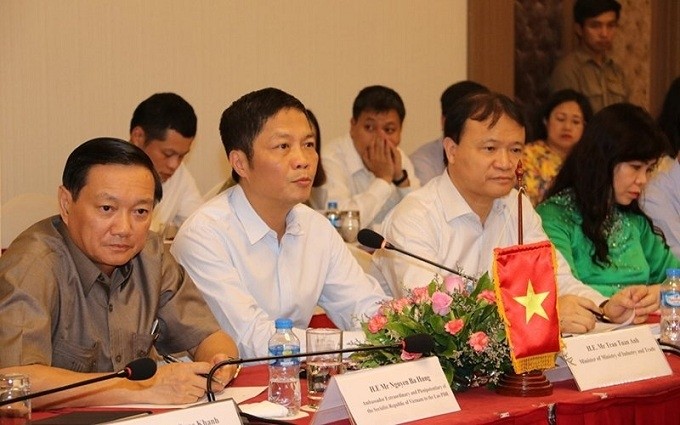 Minister of Industry and Trade Tran Tuan Anh (second from left) attends the development cooperation conferences with the Lao ministries. (Photo: NDO)