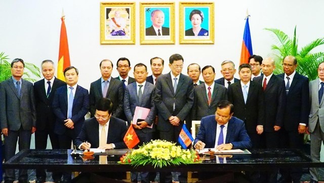 Vietnamese Deputy Prime Minister and Foreign Minister Pham Binh Minh (L) and his Cambodian counterpart Prak Sokhonn sign a cooperation agreement covering specific collaboration programmes in 28 areas. (Photo: VNA)