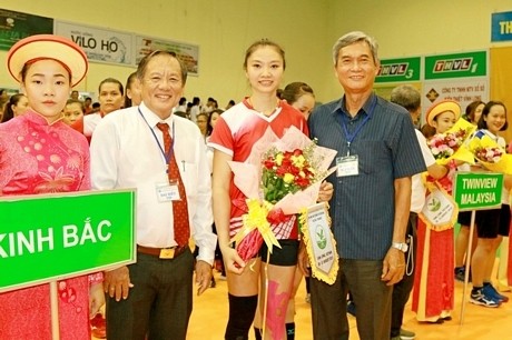 The organising board presents flowers to a volleyball player at the opening ceremony of the tournament (Photo: baovinhlong.com.vn)