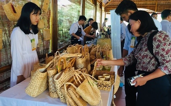Delegates experience eco-friendly products used in tourism introduced at the seminar. (Photo: baotainguyenmoitruong.vn)