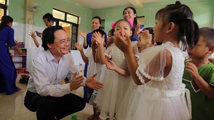 Minister of Education and Training Phung Xuan Nha shares new school year’s joy with children at Tan Hoa Commune’s kindergarten (Photo: Ministry of Education and Training)