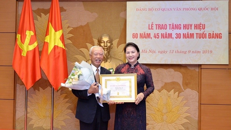 Former NA Chairman Nguyen Van An (L) receives the 60-year Party membership insignia. (Photo: VOV)