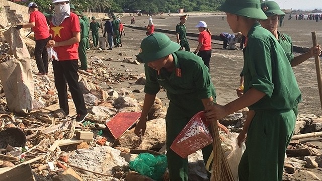 Soldiers join local people in collecting garbage and plastic waste along Do Son beach in Hai Phong city in response to a campaign to make the world cleaner