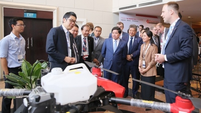 Delegates inspect modern machinery on display on the sideline of the forum. (Photo: NDO/Phuc Huy)