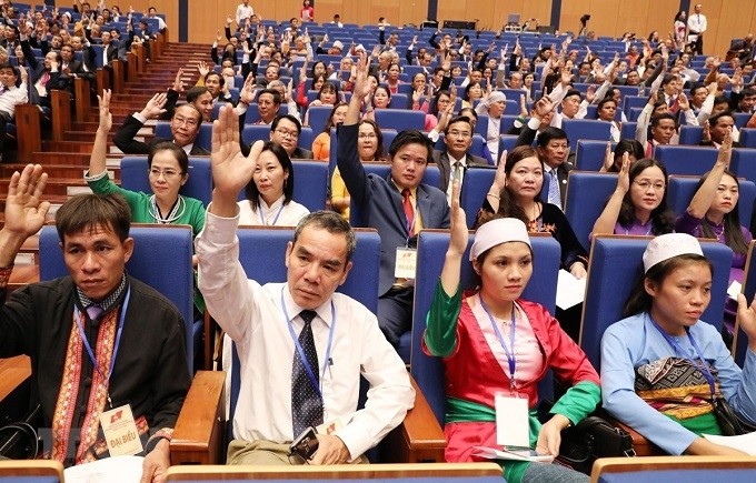 Delegates vote to approve the draft number of members of the ninth-tenure VFF Central Committee during the September 20 sitting. (Photo: VNA)