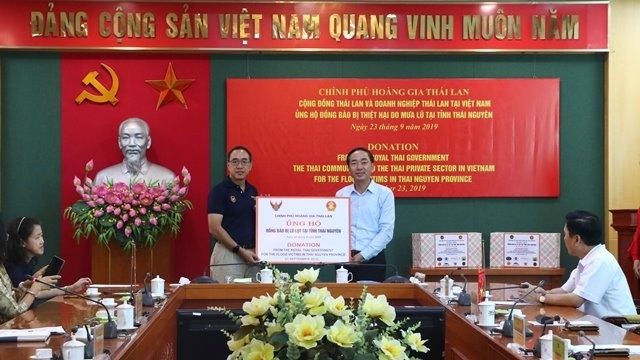 Secretary of the Thai Nguyen Provincial Party Committee, Tran Quoc To (R) receives gifts from the Thai side in support of the disaster-stricken victims in Thai Nguyen. (Photo: thainguyen.gov.vn)